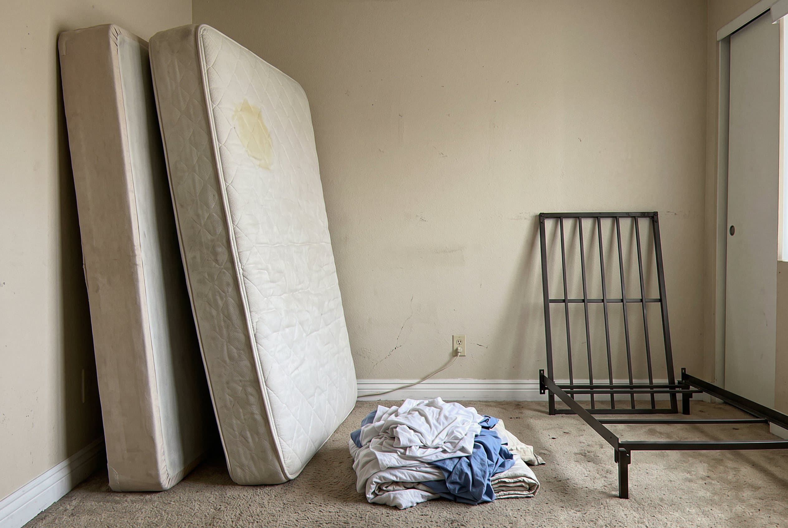 Old mattress leaning against a bedroom wall